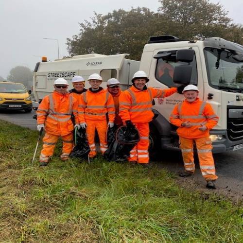 Streetscape crew in orange stood by waste lorry